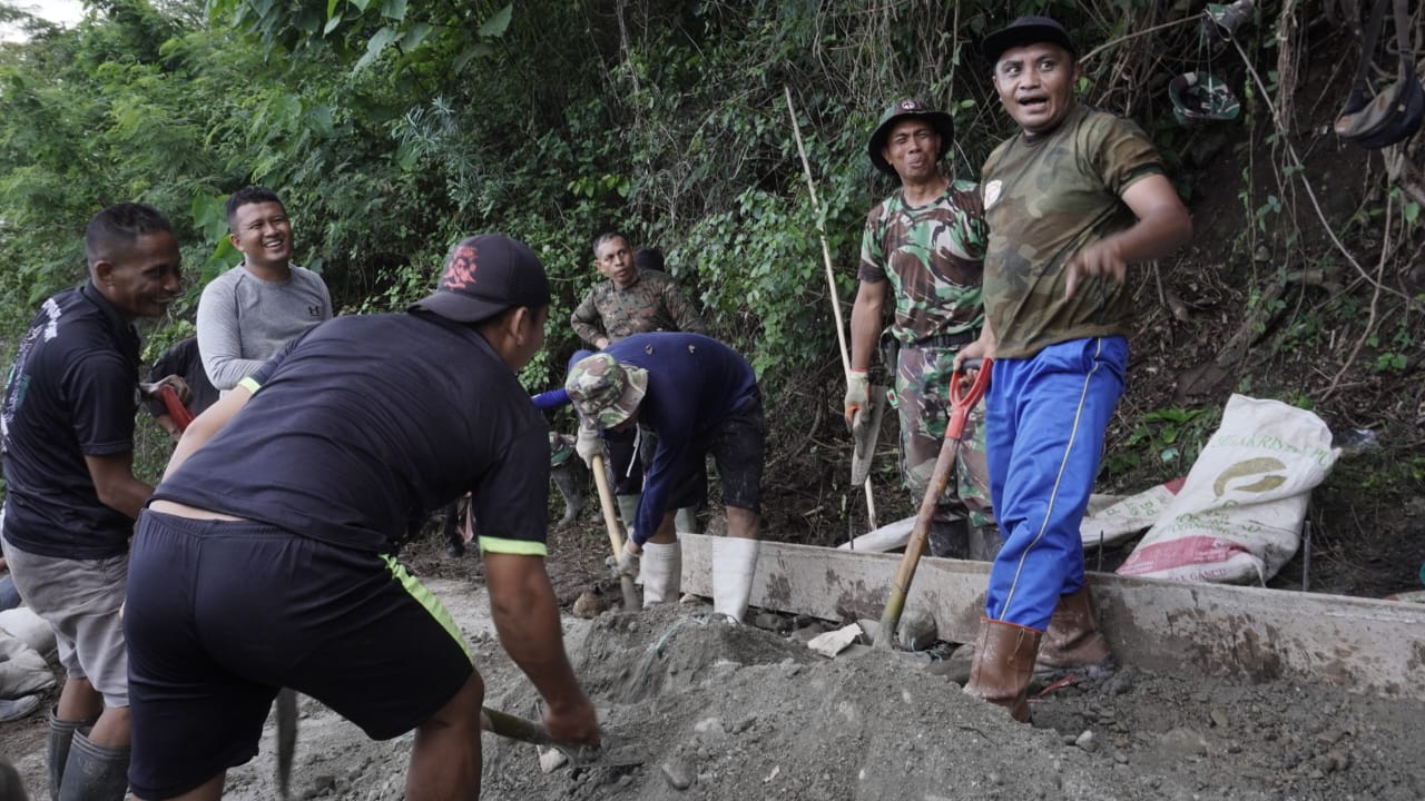 Anggota Satgas TMMD dan Warga Tetap Semangat Dalam Bekerja