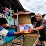 Naik Perahu, Pj Gubernur Gorontalo Berikan Bantuan Bagi Warga Terdampak Banjir di Desa Tabumela